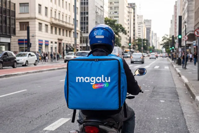 Entregador de moto com a mochila azul do Magalu Delivery na Avenida Paulista